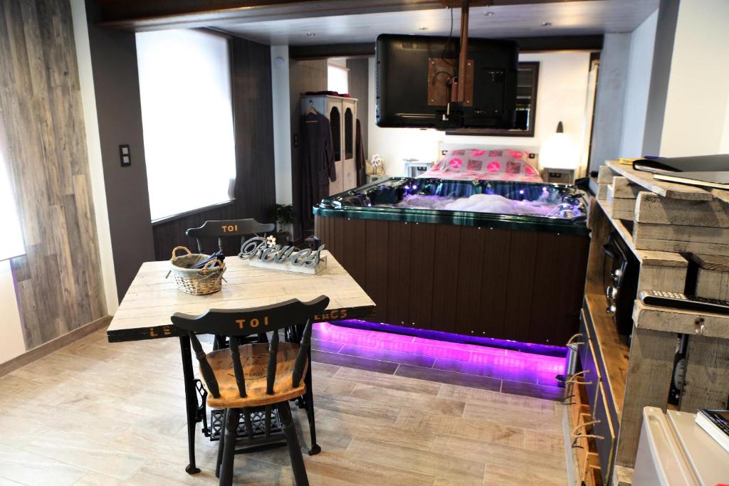 eine Bar in einer Küche mit einem Tisch und Stühlen in der Unterkunft Le cocon des lacs in Boussu-lez-Walcourt