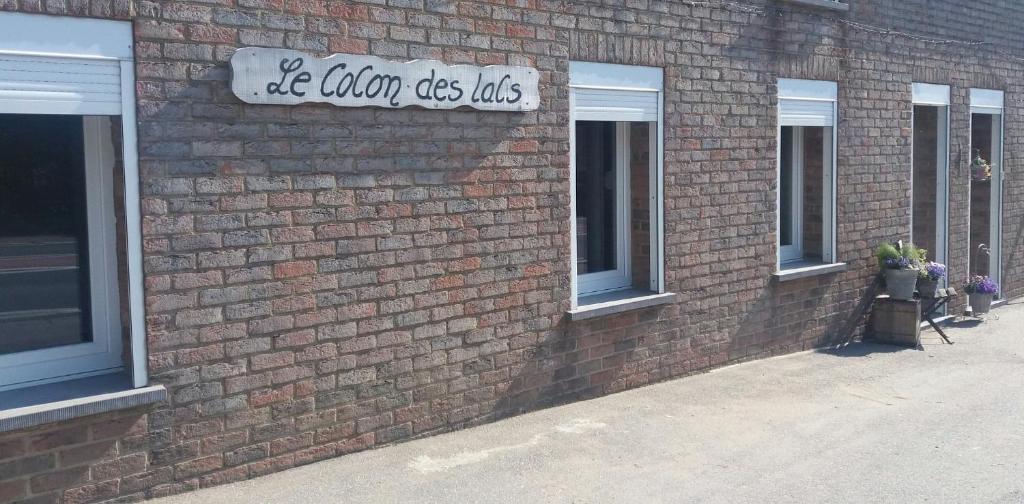 a brick building with a sign on the side of it at Le cocon des lacs in Boussu-lez-Walcourt