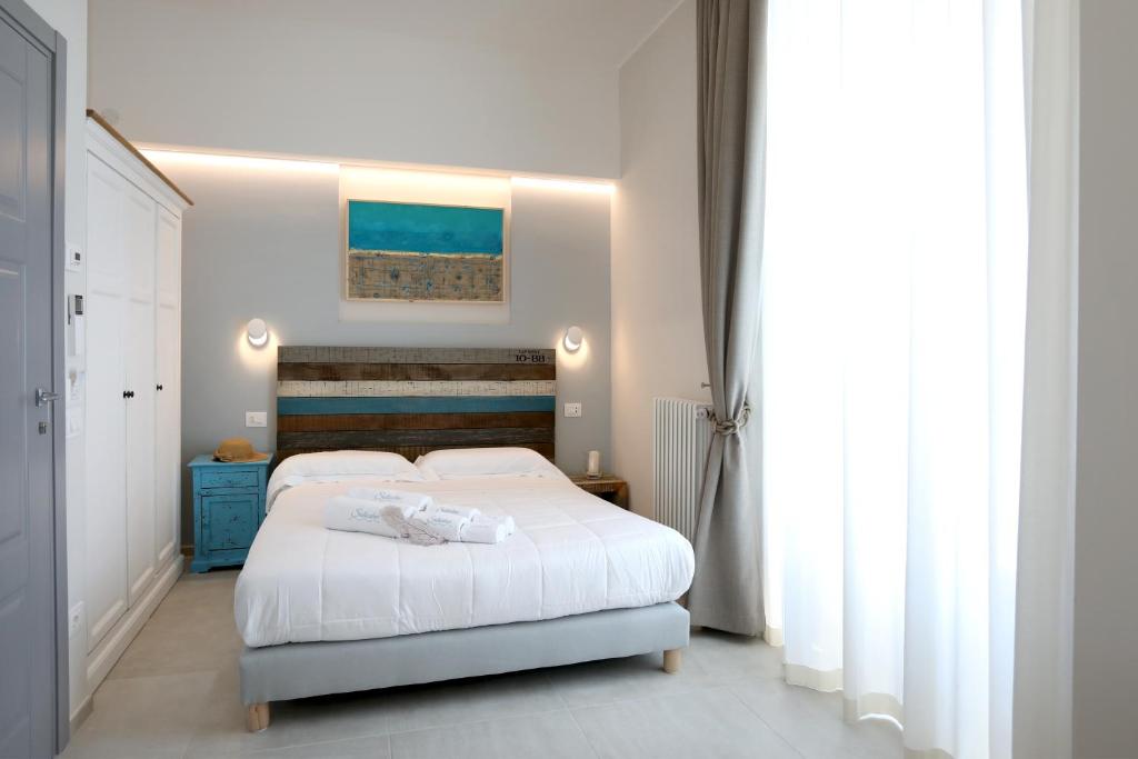 sypialnia z białym łóżkiem i niebieską szafką w obiekcie Dimora Marinucci w mieście Termoli