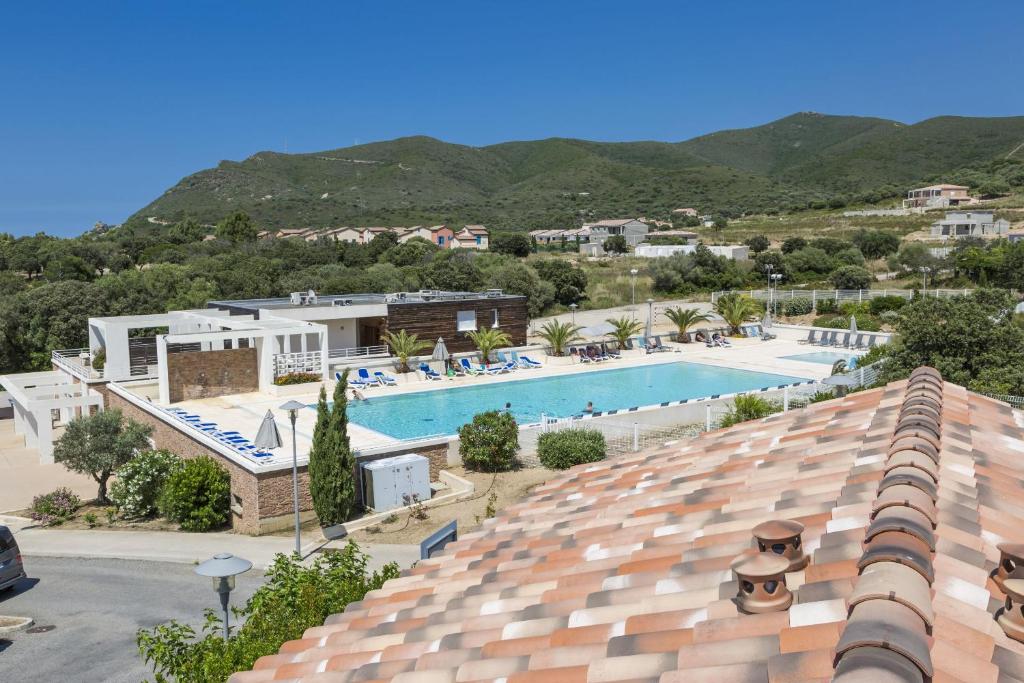 vistas a la piscina desde la azotea de un hotel en Résidence Club Odalys Les Villas de Bel Godère, en Belgodère