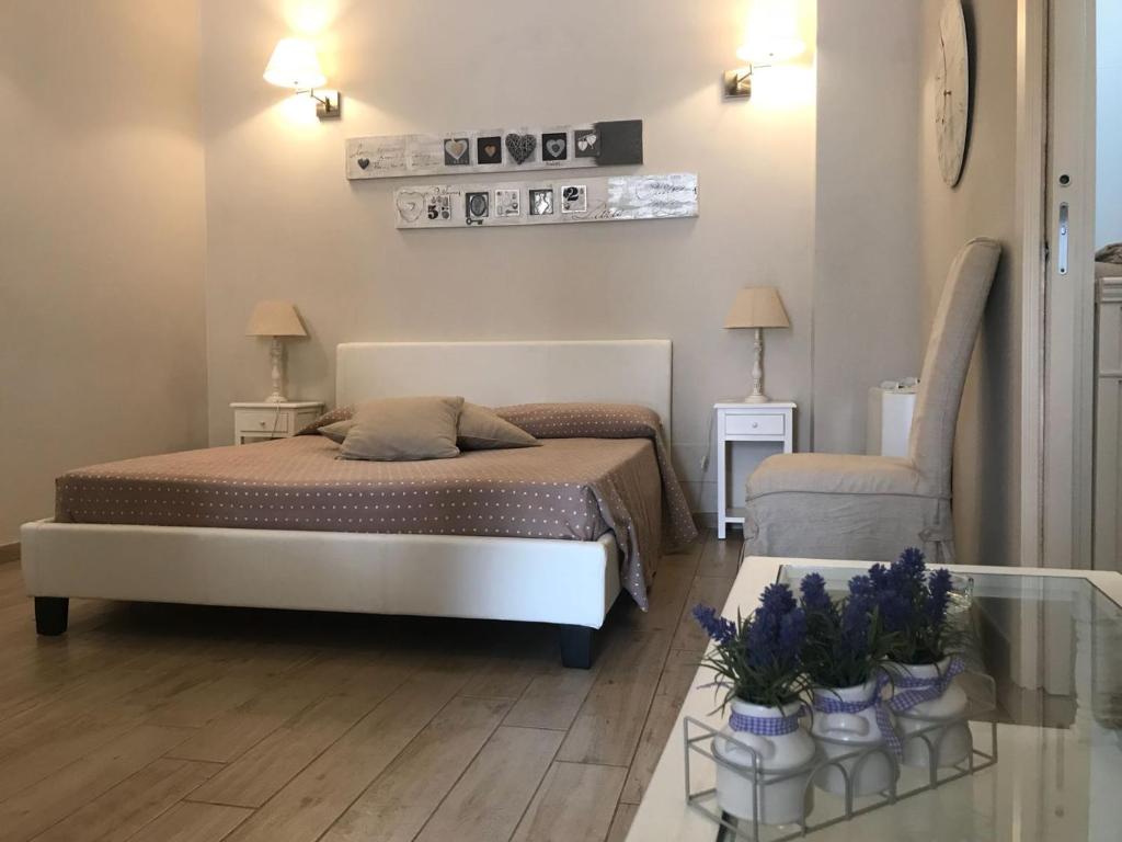 1 dormitorio con 1 cama y 1 mesa con flores en Masseria Casanova, en Lucera