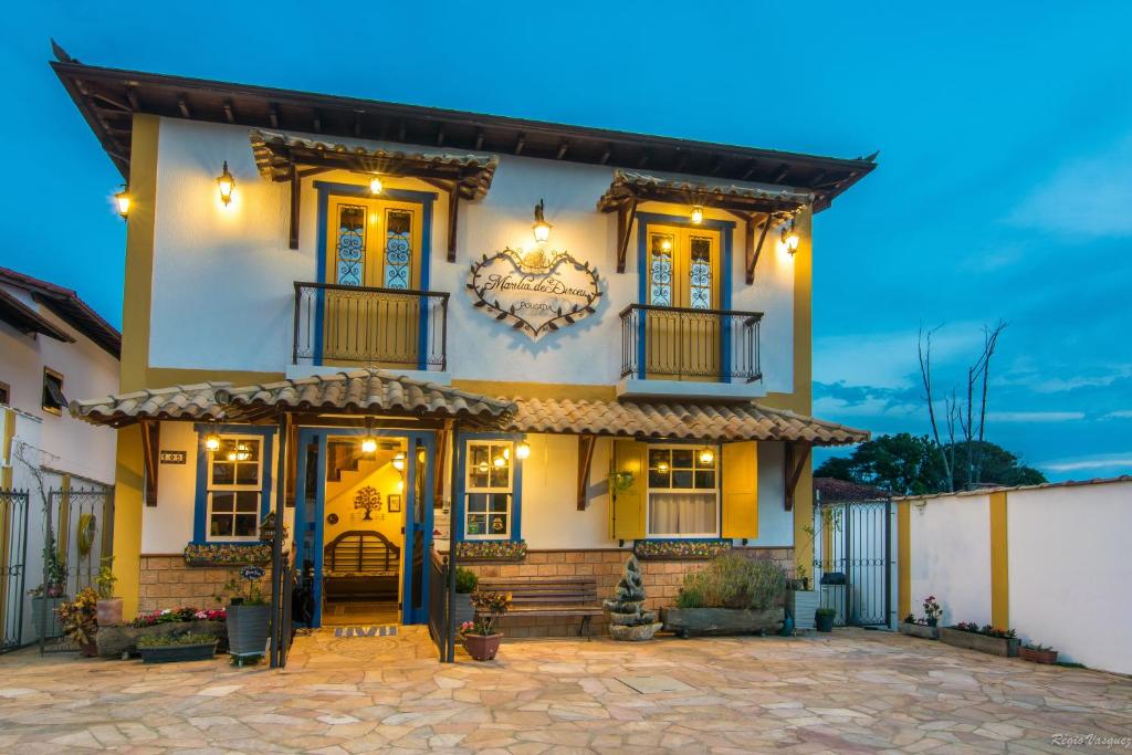 Cette grande maison blanche dispose d'une terrasse couverte. dans l'établissement Pousada Marília de Dirceu, à Tiradentes