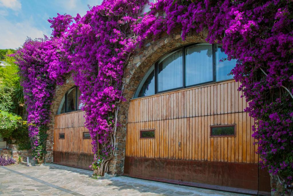 a wooden garage with purple flowers on it at Villa Eliodora in Arenzano