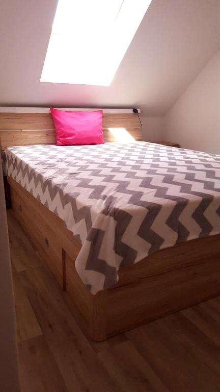 a bedroom with a large bed with a pink pillow at Penzion Malaika in Svitavy