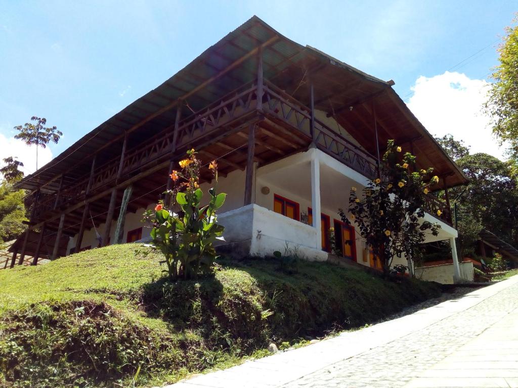 une maison sur une colline avec un arbre devant elle dans l'établissement Hostal Encanto La Salada, à Jardín