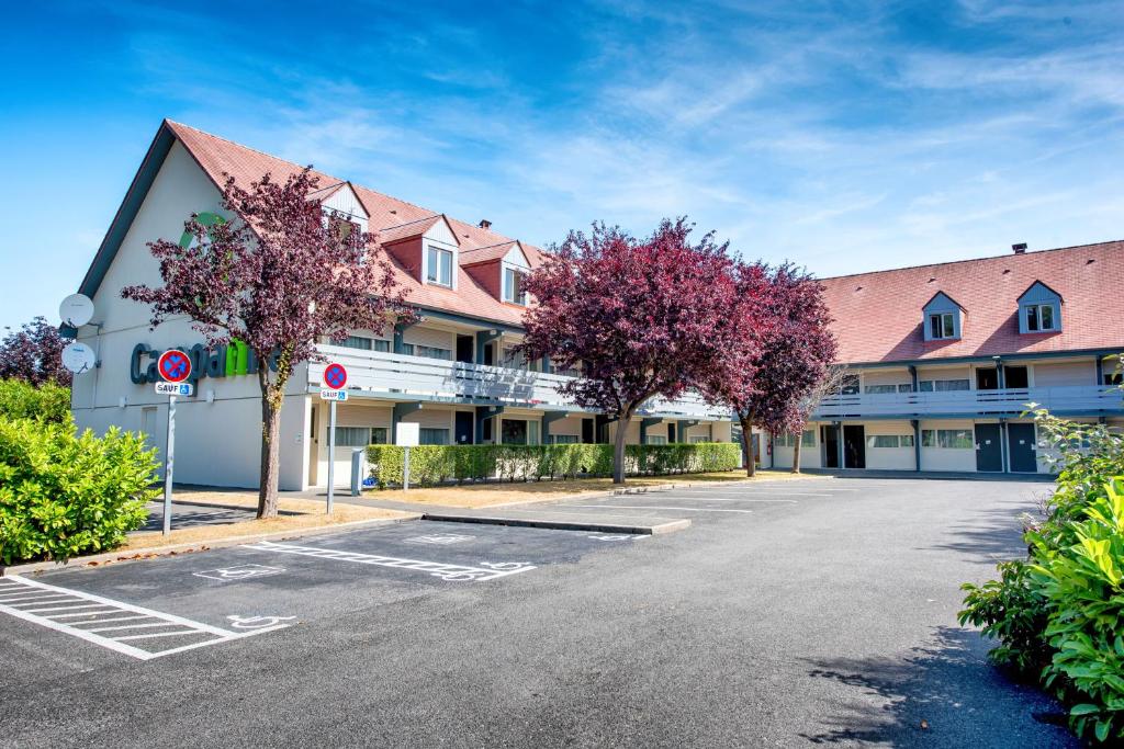 un aparcamiento vacío frente a un edificio en Campanile Deauville Saint-Arnoult, en Deauville