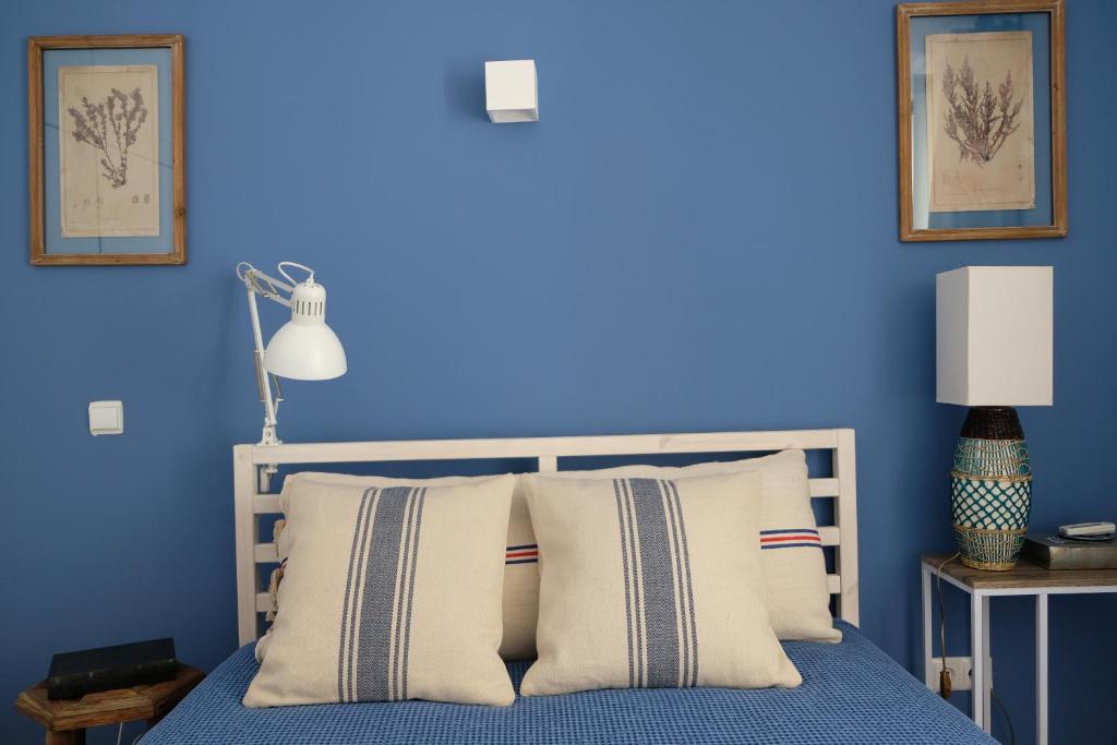 a blue bedroom with a bed with white pillows at Yellow House - Checkinhome in Boliqueime