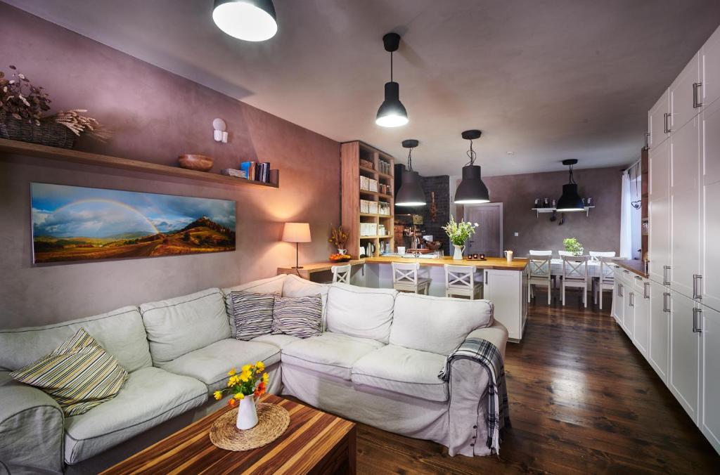 sala de estar con sofá blanco y cocina en Sad nad Klingerom, en Banská Štiavnica