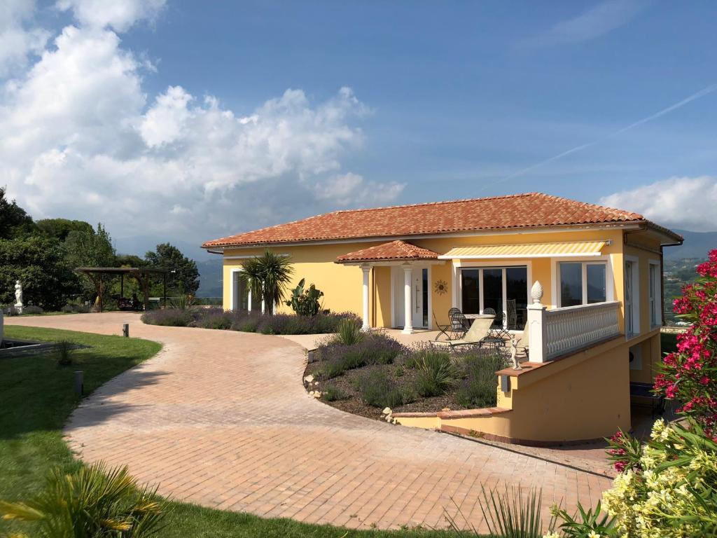 a small yellow house with a brick driveway at Villa Camporosso in Camporosso