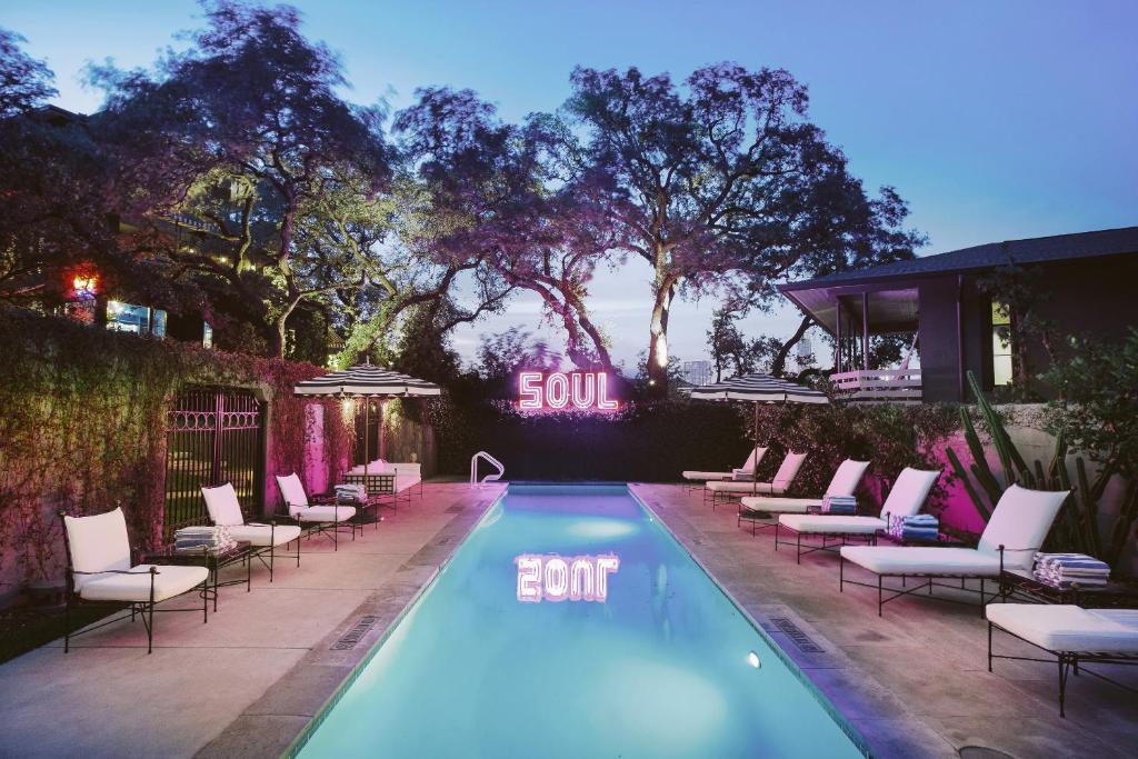a swimming pool with lounge chairs next to a building at Hotel Saint Cecilia in Austin