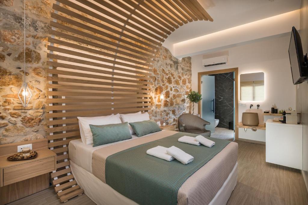 ein Schlafzimmer mit einem großen Bett und einer Holzwand in der Unterkunft Agave Suites in Chania