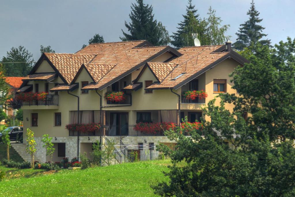 una casa con techo de baldosa en una colina en Zrinka House en Grabovac