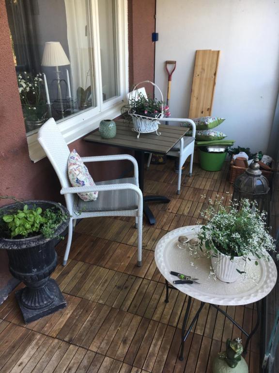 un porche con 2 sillas y una mesa con plantas en Farsta Bed and Breakfast, en Estocolmo