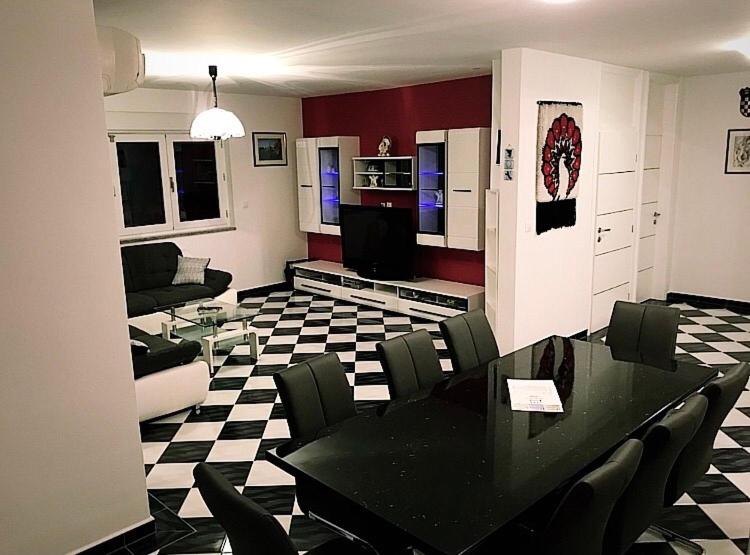 a living room with a black table and chairs at Mundial Apartments in Njivice