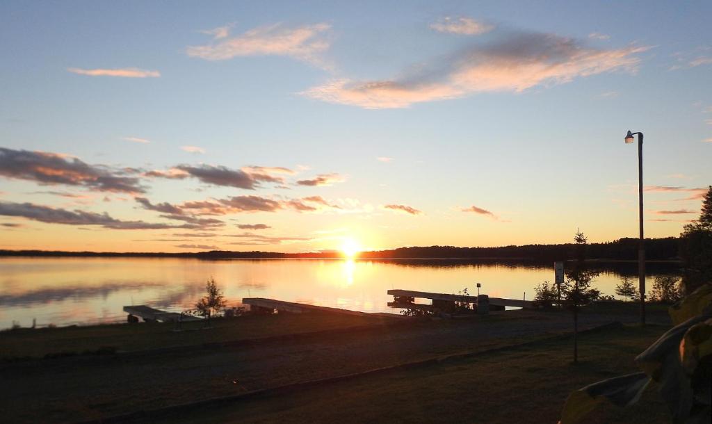 a sunset over a body of water with a dock at WildExodus Outdoors in Timmins