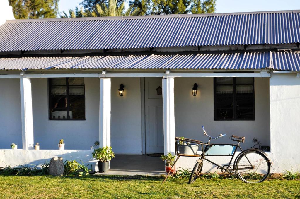 una bicicletta parcheggiata di fronte a una casa bianca di Avonsrus Guesthouse ad Augrabies