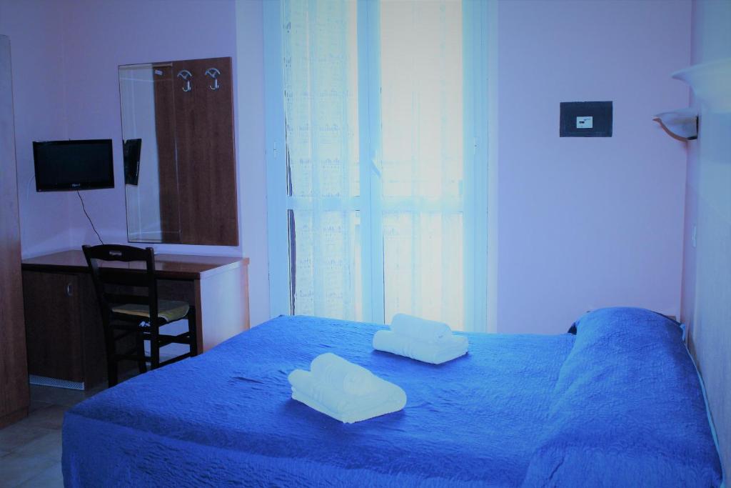 a bedroom with a blue bed with two pillows on it at Hotel Moon Light in Rome