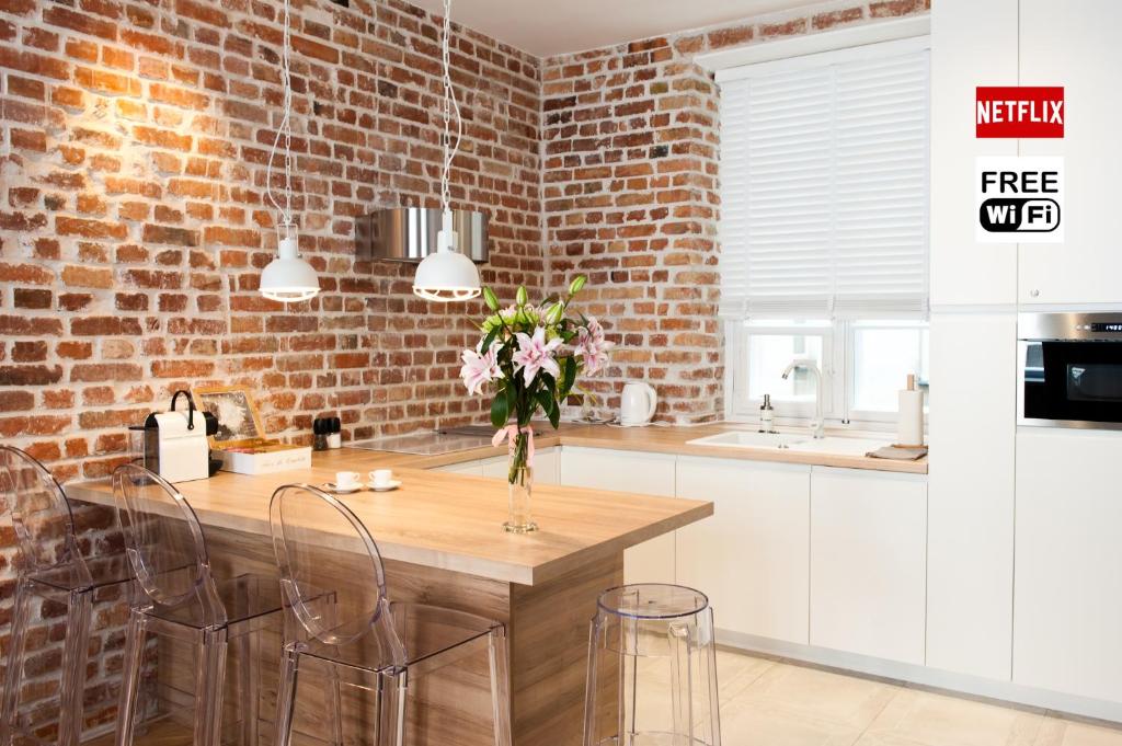a kitchen with a table with chairs and a brick wall at Red Brick Old Town Apartment in Warsaw