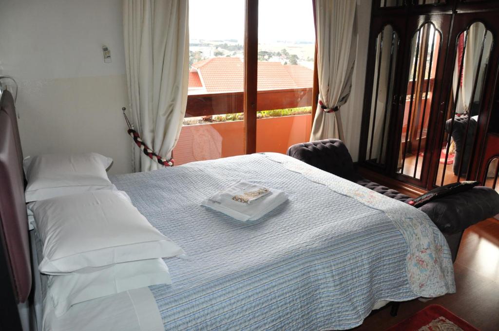 a bedroom with a bed with a tray on it at Pousada Monte Carlo in São Joaquim