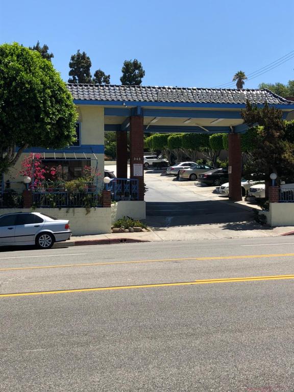 um carro estacionado em frente a uma bomba de gasolina em King Lodge Motel em Monterey Park