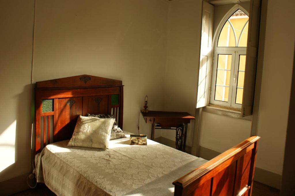 a bedroom with a wooden bed and a window at 157 Rua Emídio Navarro in Luso