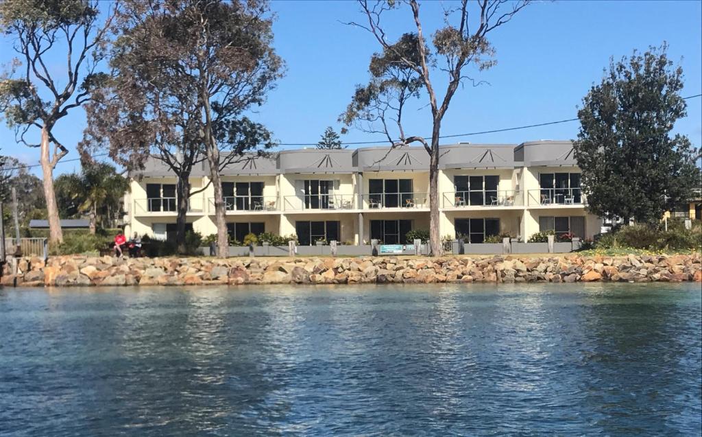 een gebouw aan de oevers van de rivier bij Merimbula Lake Apartments in Merimbula