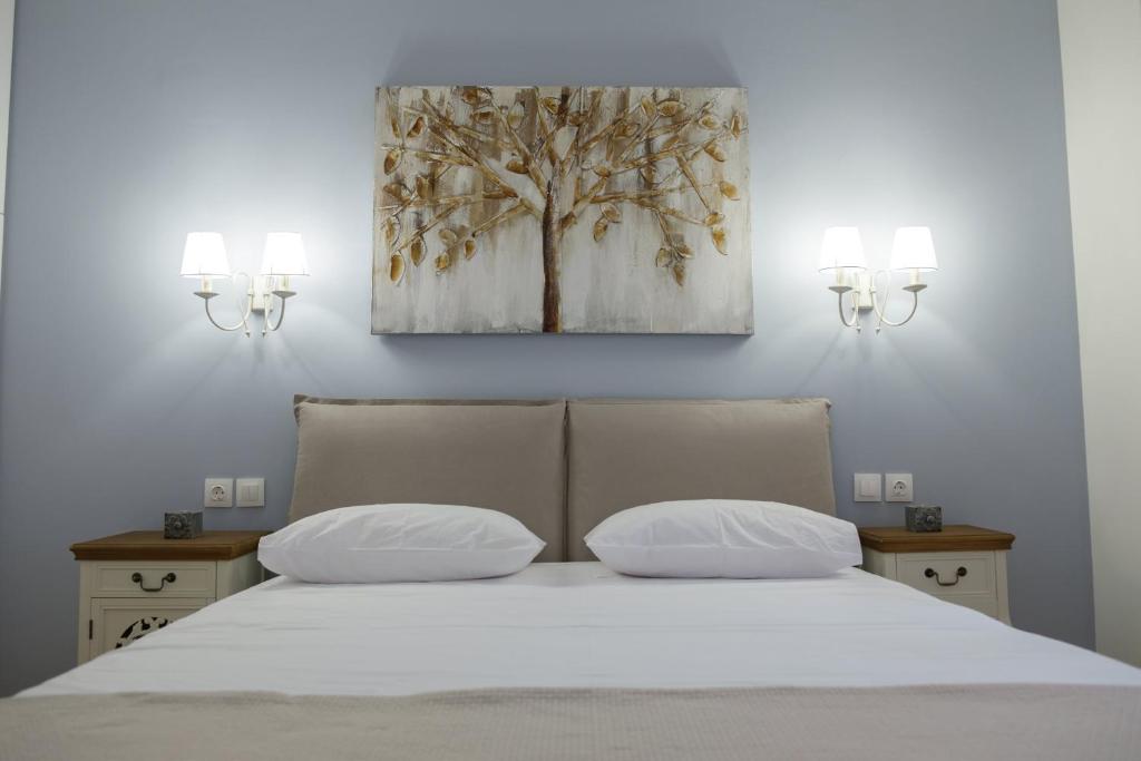 een bed met twee kussens en een schilderij aan de muur bij Elegant 2BD Apartment in the heart of Athens in Athene