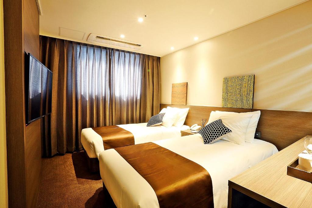 Postel nebo postele na pokoji v ubytování Grandmillions Hotel Seogwipo