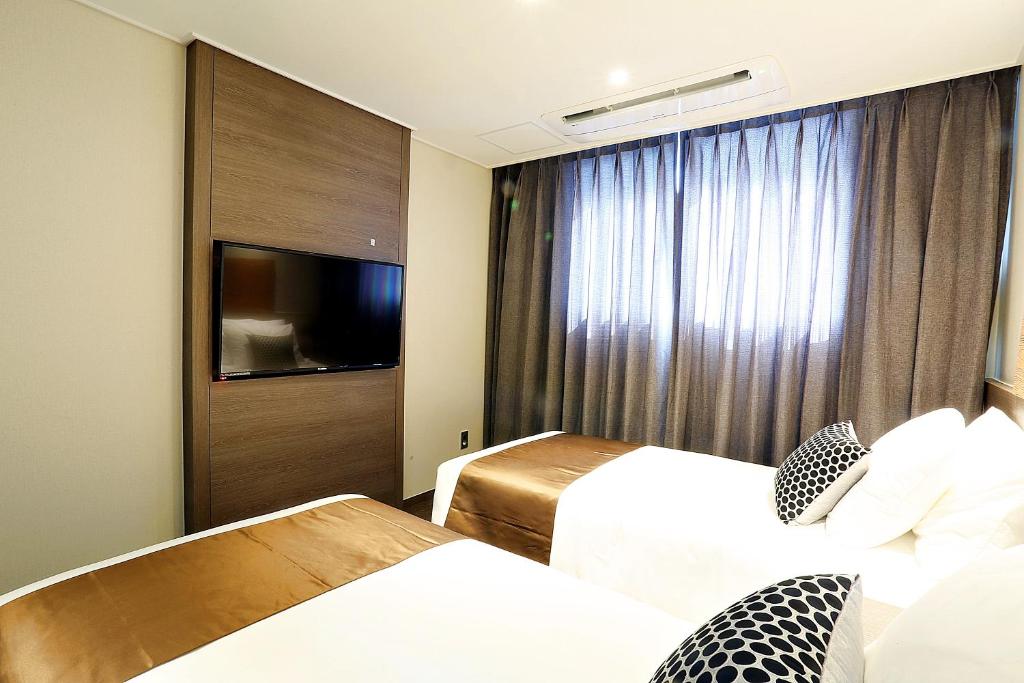 Postel nebo postele na pokoji v ubytování Grandmillions Hotel Seogwipo