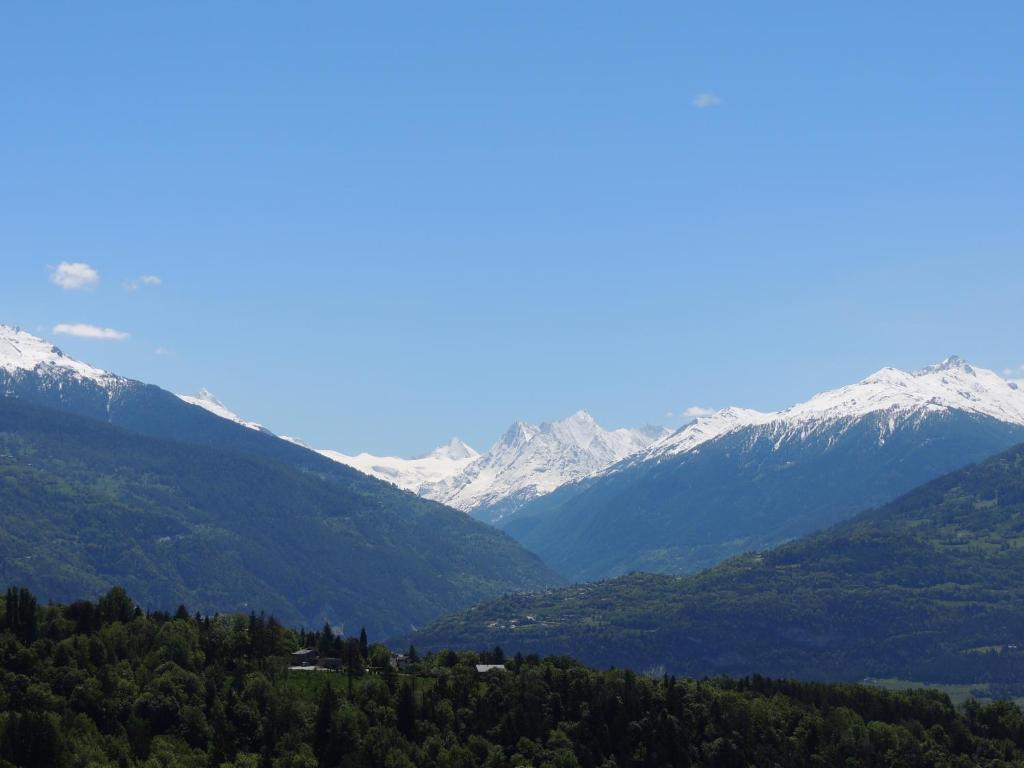 a valley with snow capped mountains in the distance at Chambre d'hôte du Moulin in Savièse