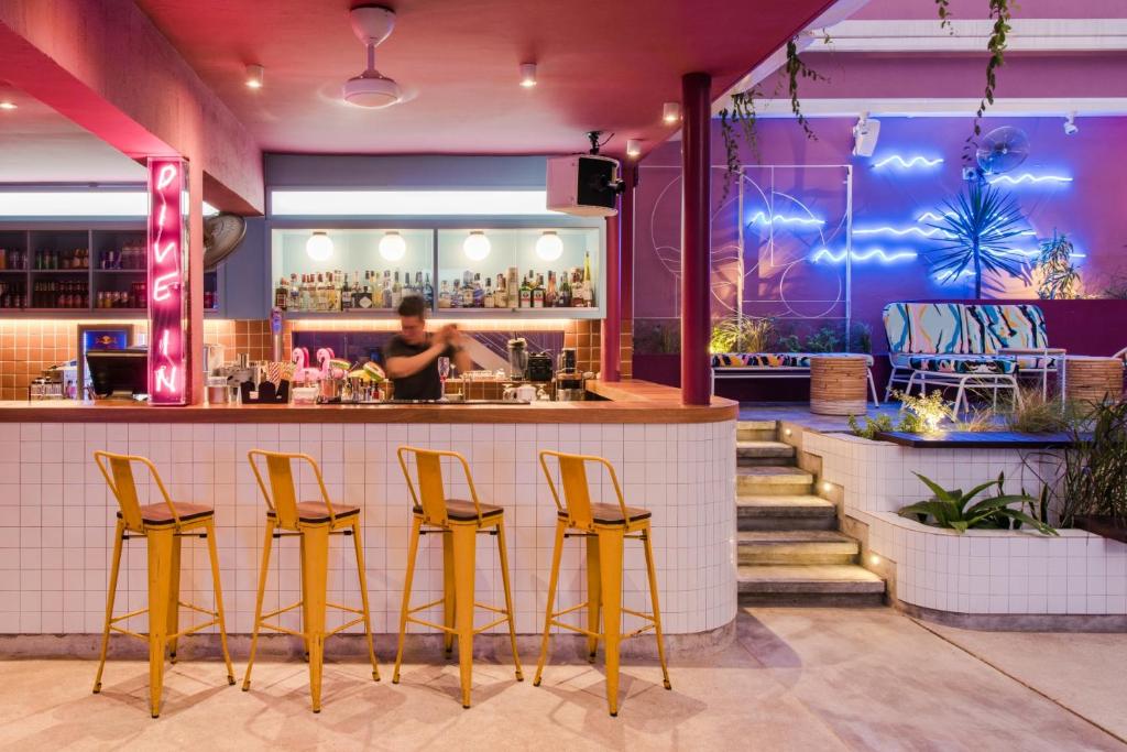 a bar in a restaurant with yellow stools at The Kuala Lumpur Journal Hotel in Kuala Lumpur