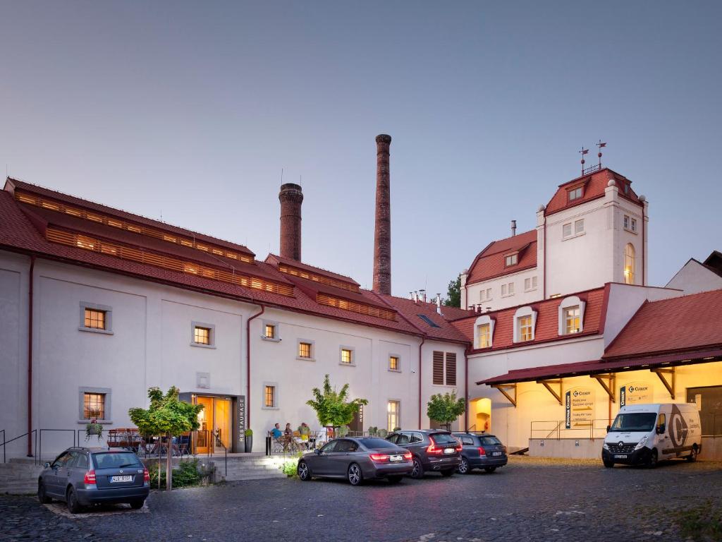 un gruppo di auto parcheggiate in un parcheggio di fronte a un edificio di Hotel Kleis a Cvikov