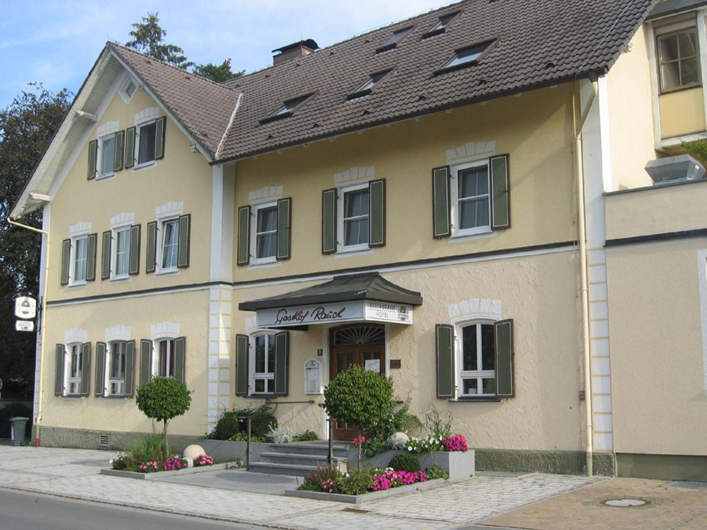 a large yellow building with flowers in front of it at Hotel Rauch in Ettringen