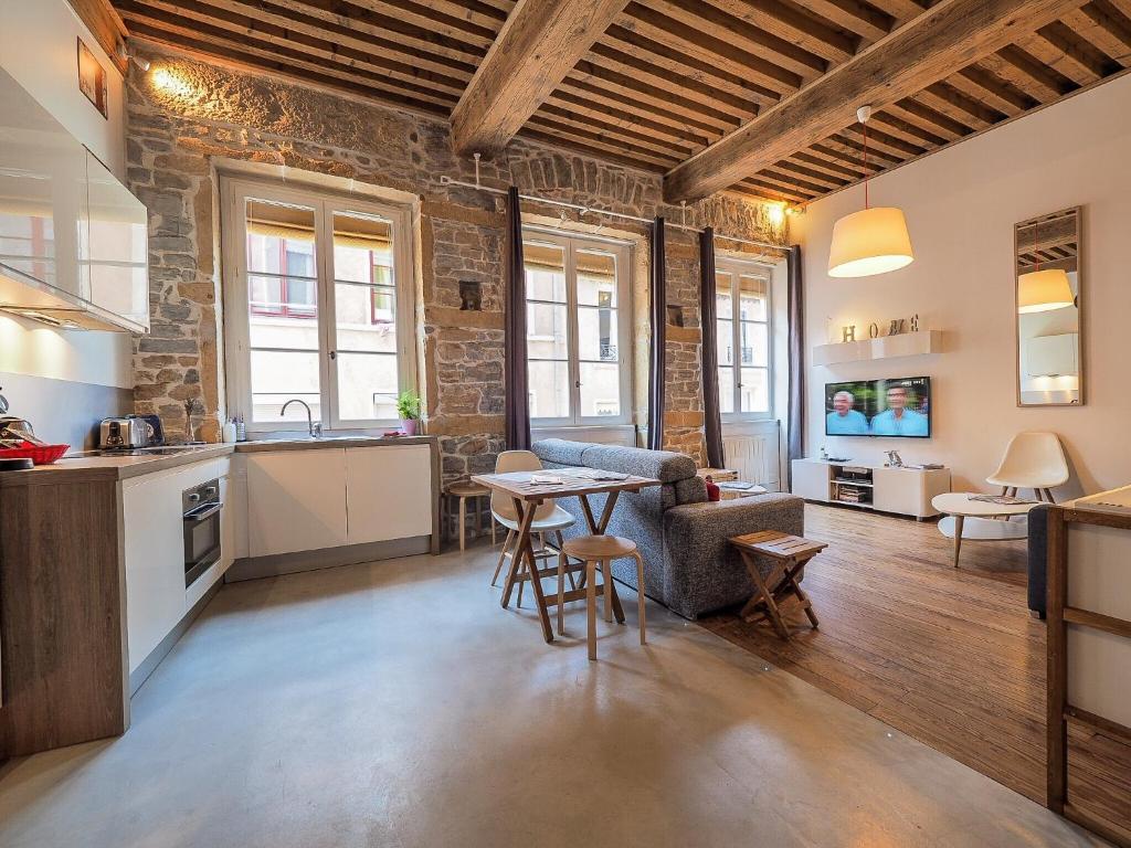 a kitchen and living room with a table in a room at La Nuit Saint Georges in Lyon