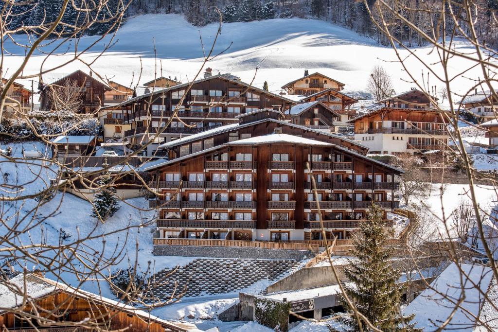 a large building in the snow with snow at Hotel le Petit Dru in Morzine