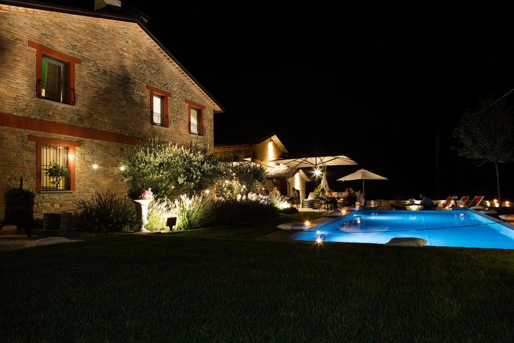 a swimming pool in front of a house at night at Agriturismo La Ratta in Vernasca