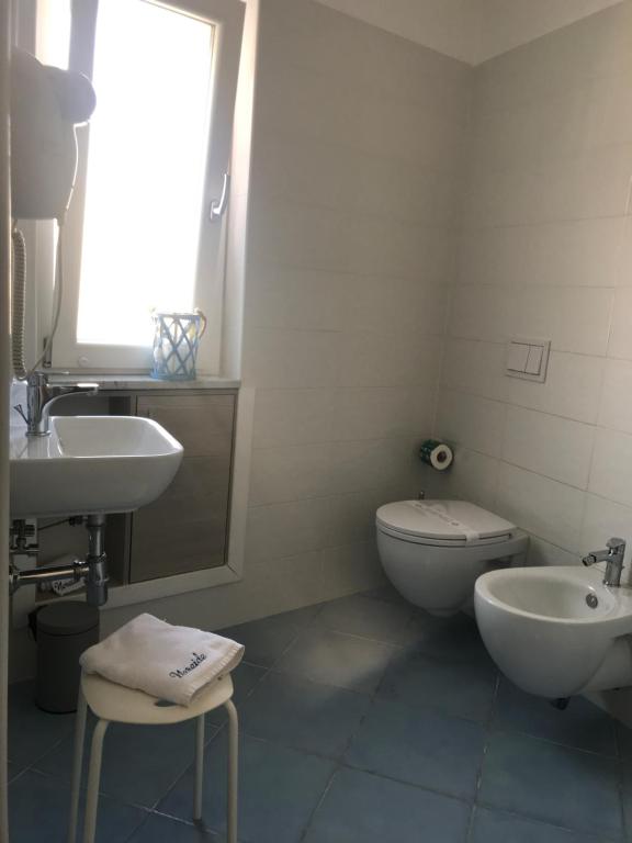 a bathroom with a sink and a toilet and a window at Nereide in Tropea