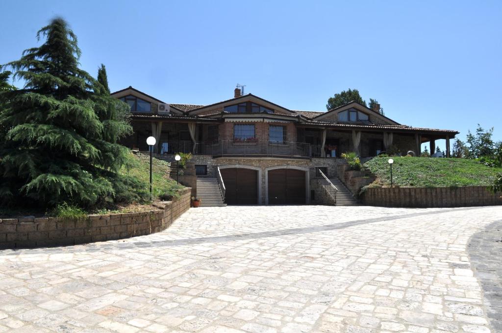 una casa grande con una entrada delante de ella en Il Casale Della Gioia, en Melfi
