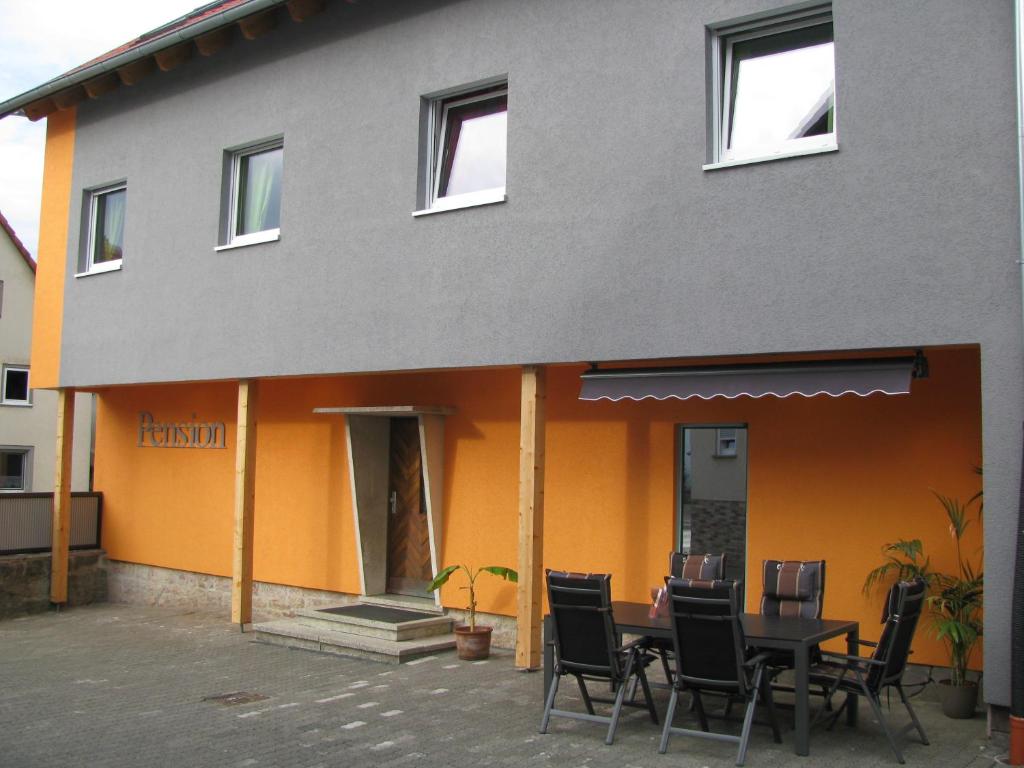 a table and chairs in front of a building at Wellness Pension Salzgrotte in Sondernau