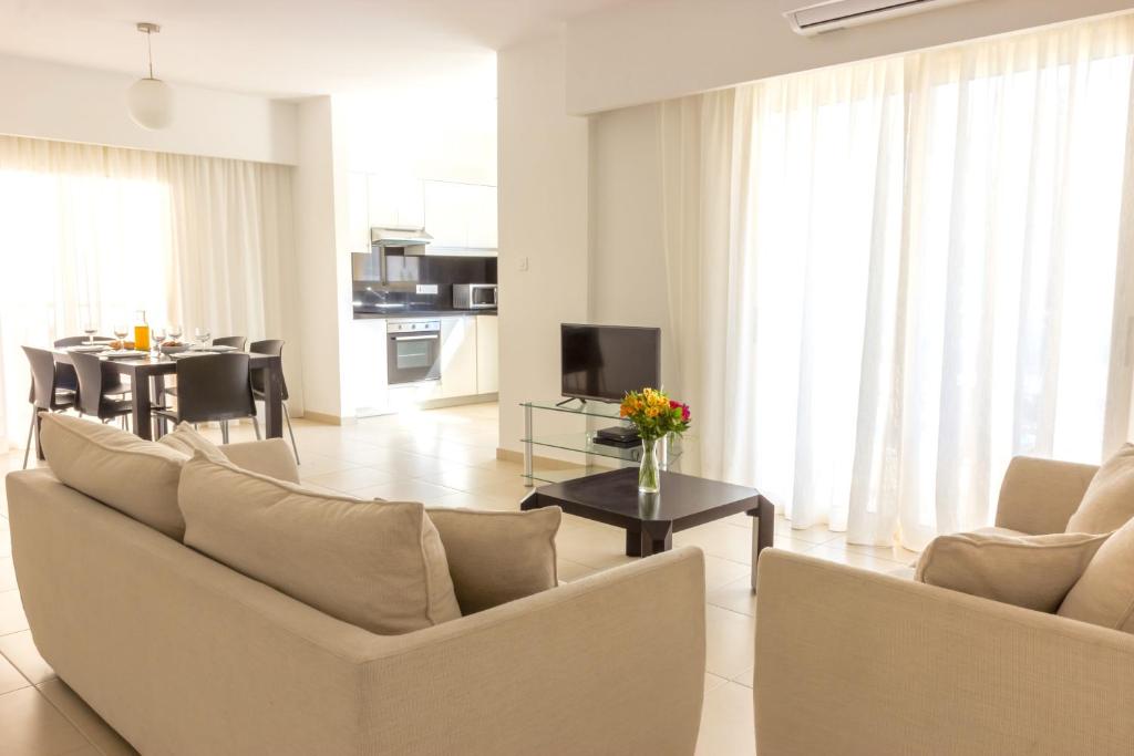 a living room with a couch and a table with flowers at Elysia Park in Paphos