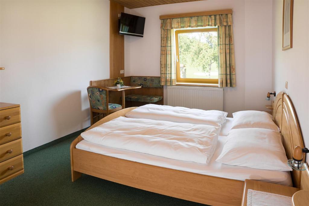 - une chambre avec un lit, un bureau et une fenêtre dans l'établissement Gasthof Pammer, à Mardetschlag