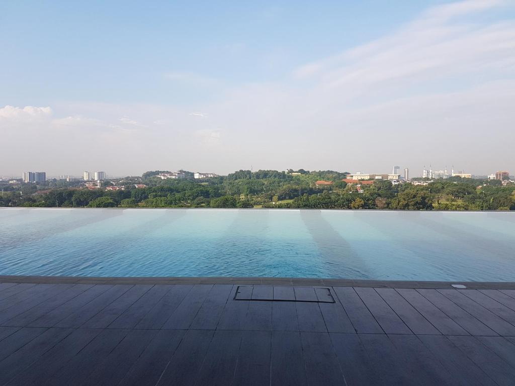 a large swimming pool with a city in the background at SJA Suria Jelutong in Shah Alam