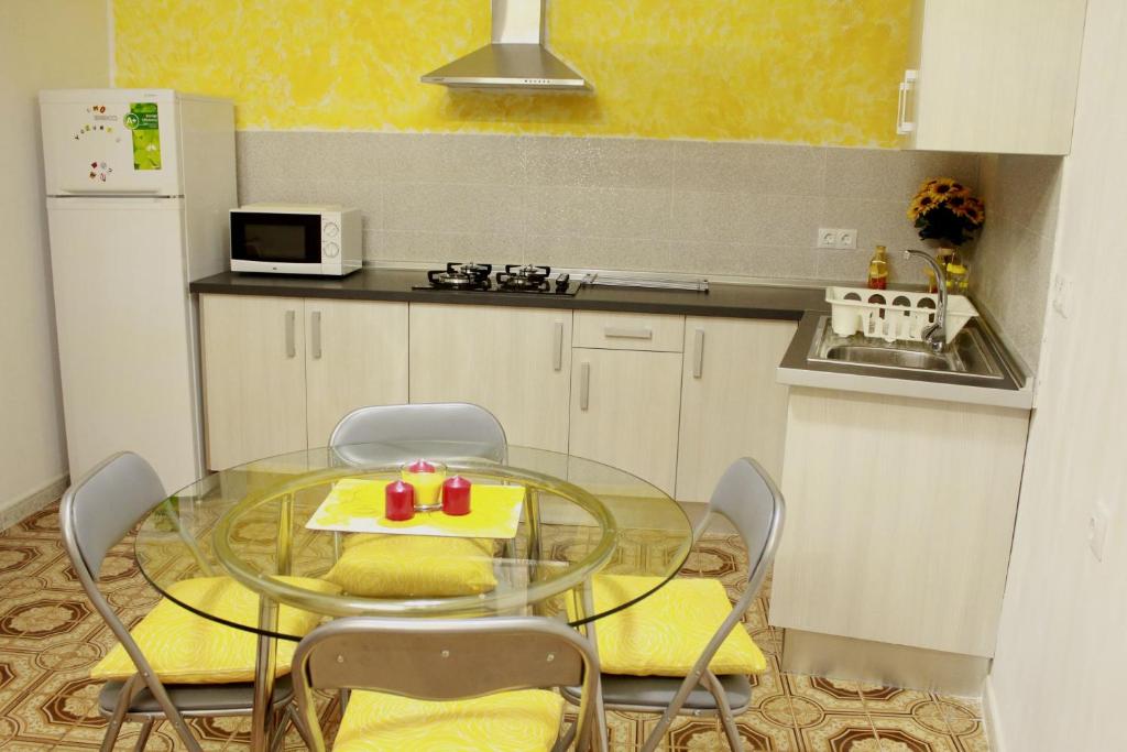 a kitchen with a glass table with chairs and a microwave at Casa Colonial Vegueta in Las Palmas de Gran Canaria