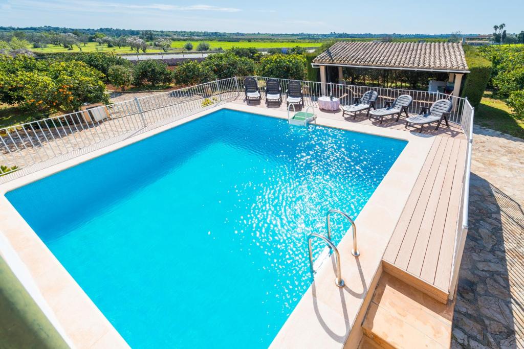 a swimming pool with chairs and a gazebo at Can Rafelino in Llubí