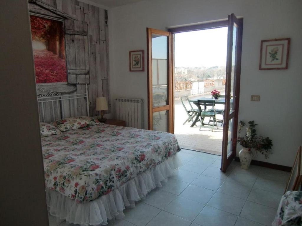 1 Schlafzimmer mit einem Bett und einem Balkon mit einem Tisch in der Unterkunft Rose Room in Rom