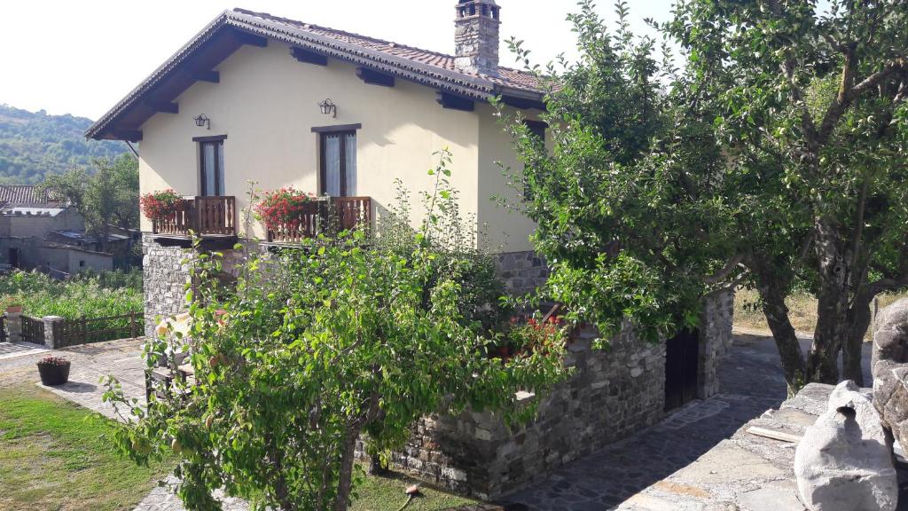 a white house with a stone wall and trees at Terrazze sul frido in Viggianello