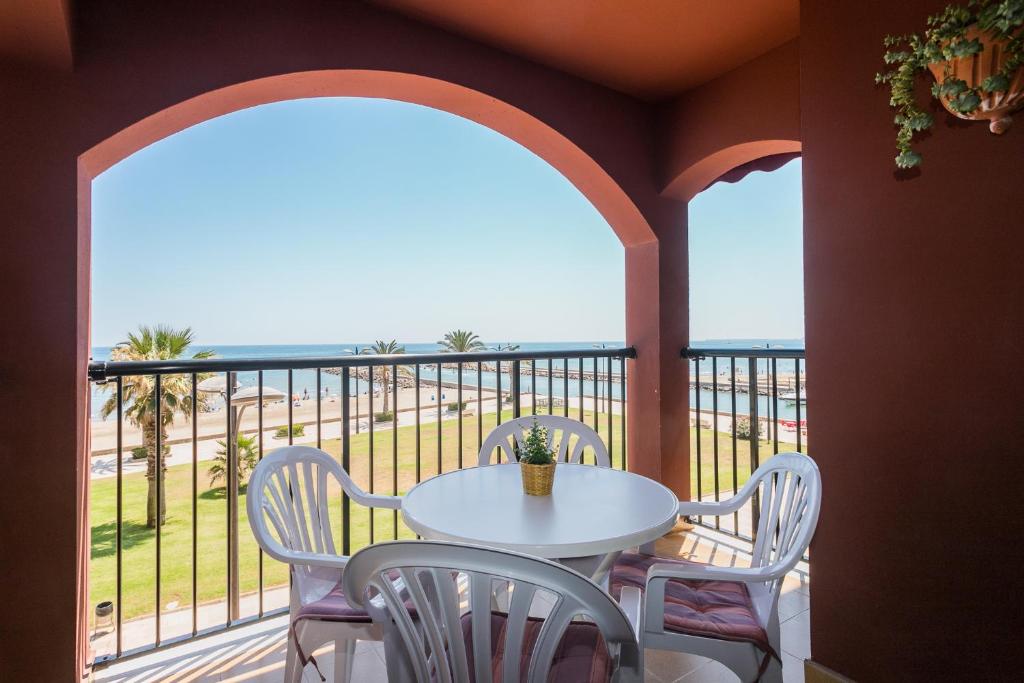 a table and chairs on a balcony with a view of the beach at ApartUP Saplaya Harbour in Alboraya