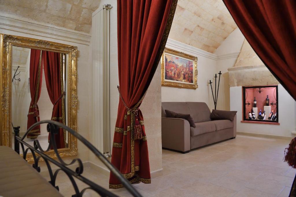 a living room with a couch and red curtains at Antica Oria in Oria