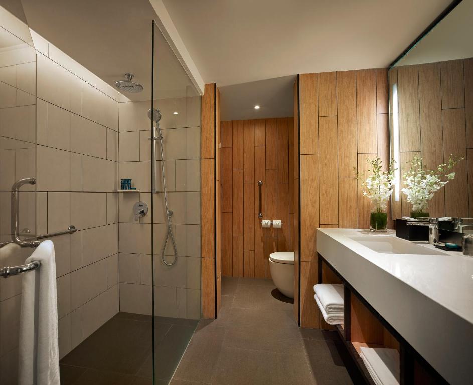 a bathroom with a shower and a toilet and a sink at PARKROYAL Penang Resort in Batu Ferringhi