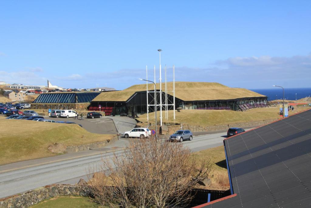 a view of a building with cars parked on a road at Nordic Inn Thorshavn in Tórshavn